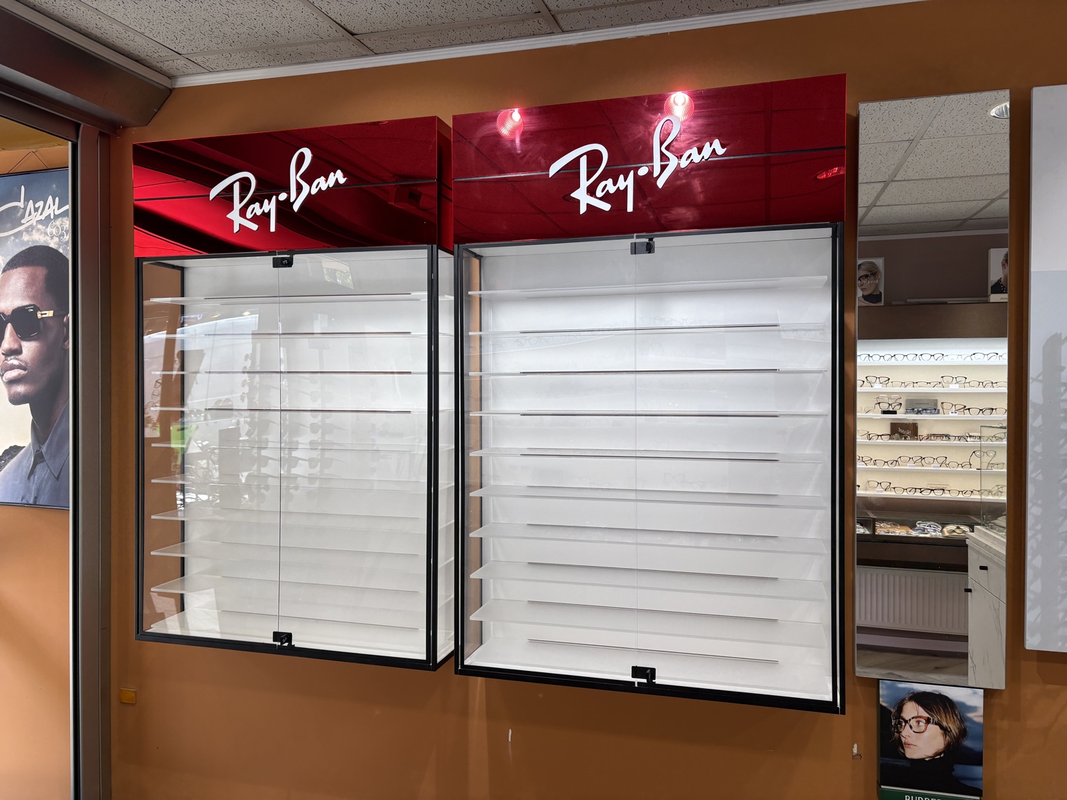 Deux vitrines murales vitrées Ray-Ban avec étagères blanches, cadres noirs et bandeaux rouge miroir